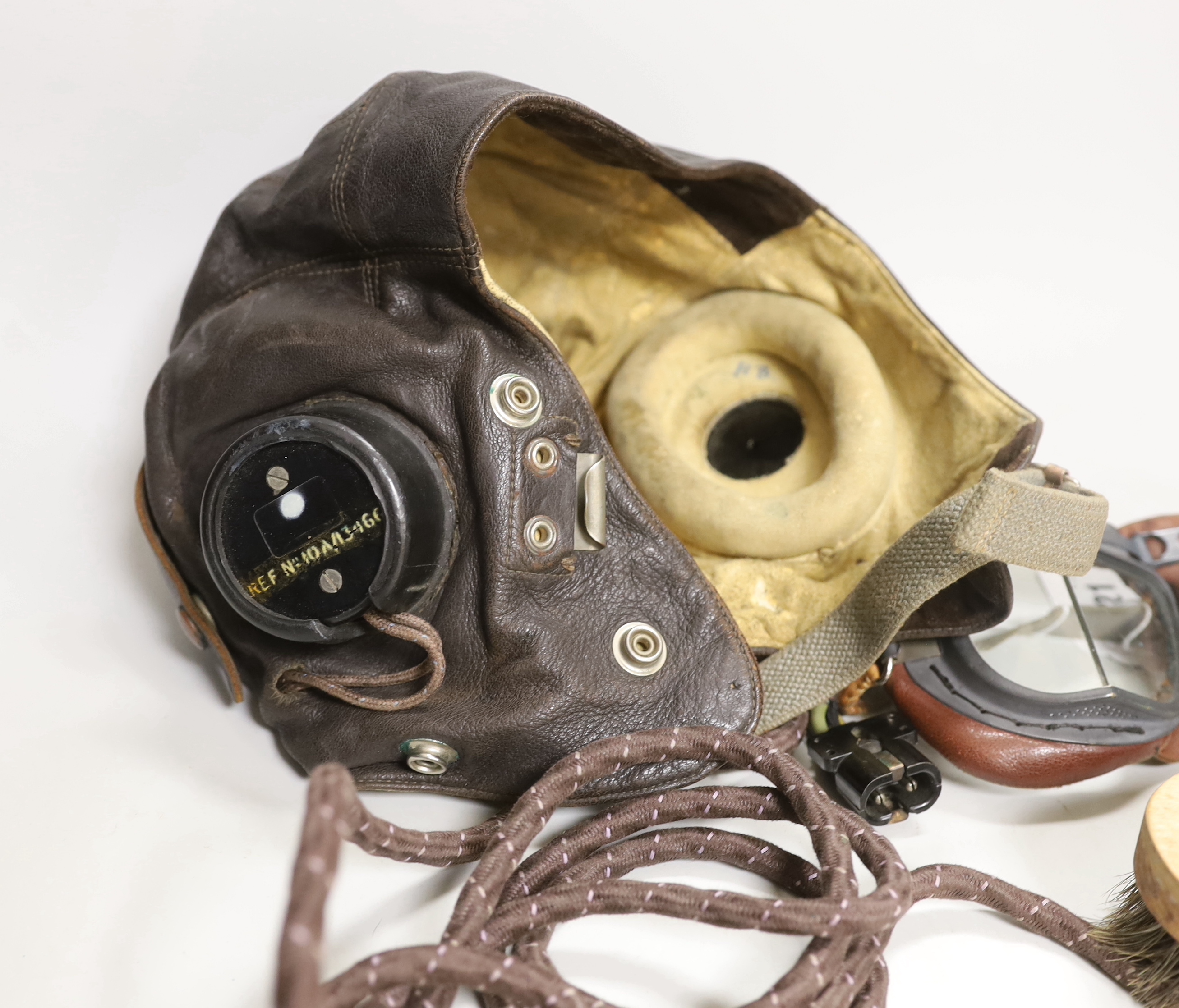 A WWII RAF flying helmet with speaker earpieces and original cables and plugs, Ref No.10A/13466, initialled in pen ‘HB’ for H. Brown 1320701, together with flying goggles and a contemporary clothes brush, provenance - by
